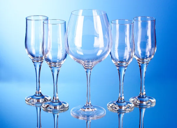 Pocas copas de vino vacías sobre fondo azul —  Fotos de Stock