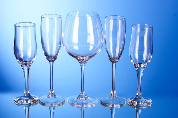 Декілька порожніх келихів для вина на синьому фоні — стокове фото