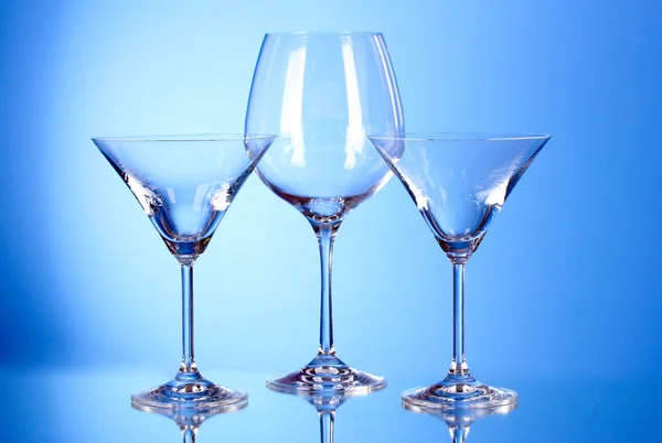 Wenige leere Weingläser auf blauem Hintergrund — Stockfoto