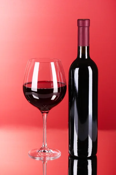 葡萄酒瓶和玻璃在红色背景 — 图库照片