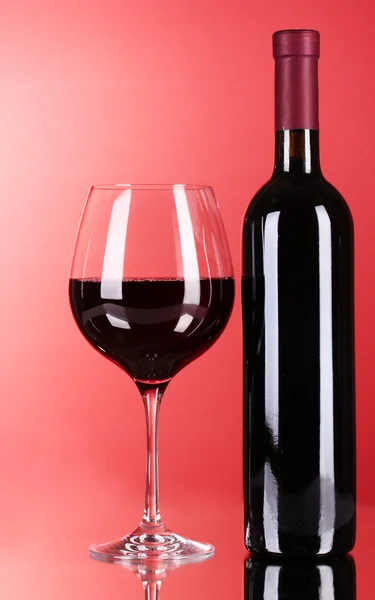 Wine bottle and glass on red background — Stock Photo, Image