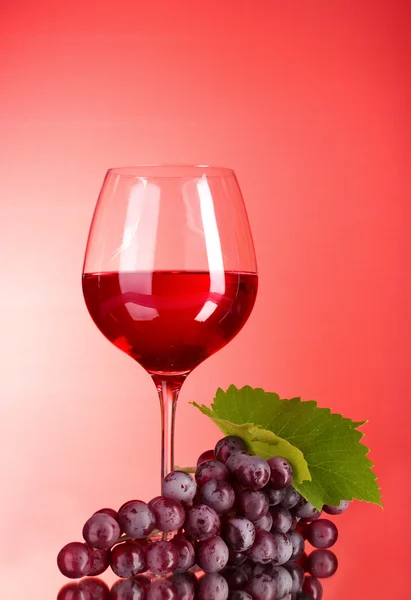 Бокал вина на красном фоне — стоковое фото