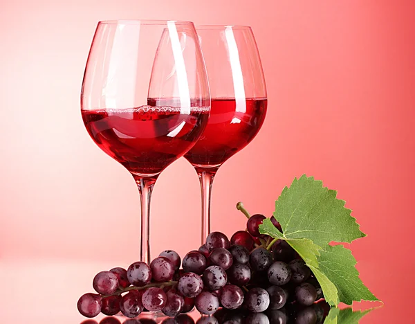 Weinflasche und Glas auf rotem Hintergrund — Stockfoto