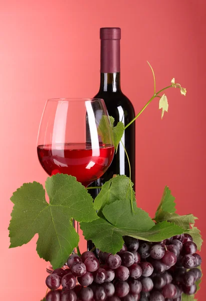 Wijn fles en glas op rode achtergrond — Stockfoto