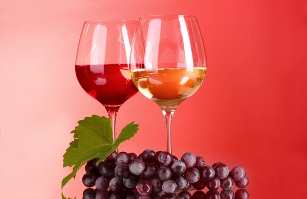 Μπουκάλι κρασί και γυαλί, σε κόκκινο φόντο — Φωτογραφία Αρχείου