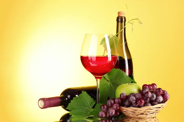Красное вино и фрукты на желтом фоне — стоковое фото