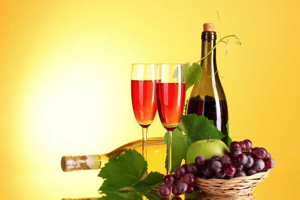 Červené víno a ovoce na žlutém podkladu — Stock fotografie