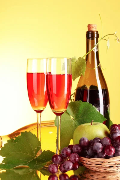 Вино и фрукты на желтом фоне — стоковое фото