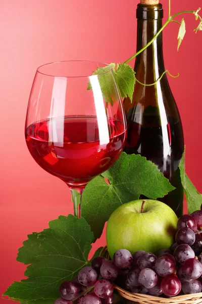 Vinho e frutas no fundo vermelho — Fotografia de Stock
