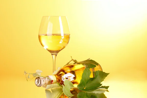 Wine and grape leaves on yellow background — Stock Photo, Image