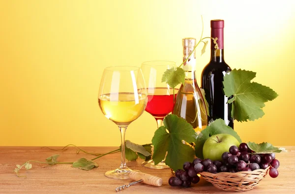 Вино и фрукты на желтом фоне — стоковое фото