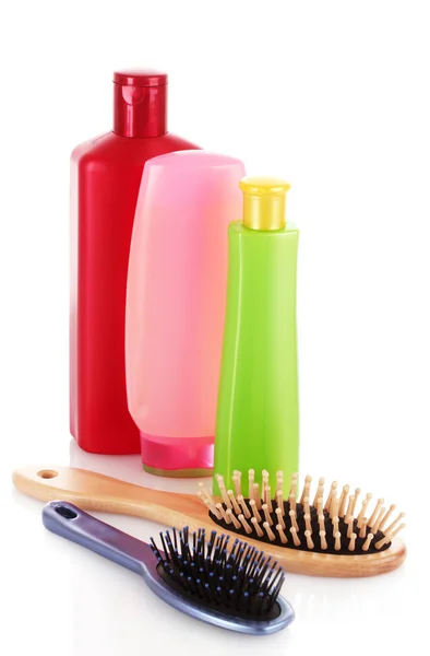 Пляшки для шампуню та щітка для волосся на білому — стокове фото