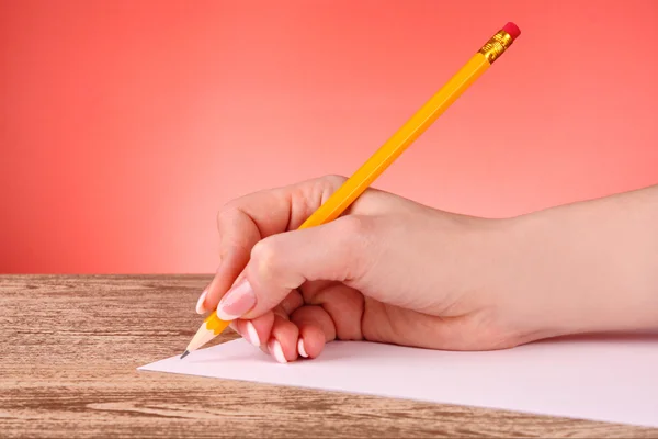 Mulher mão escrevendo lápis de madeira amarelo no papel — Fotografia de Stock