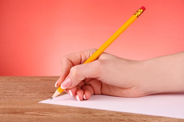 紙の上に黄色の木の鉛筆を書く女性手 — ストック写真
