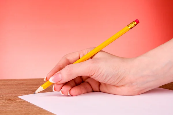 Γυναίκα χέρι γραψίματος κίτρινο ξύλινο μολύβι σε χαρτί — Φωτογραφία Αρχείου