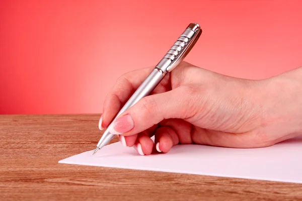 Ручка в руці, що пише на папері — стокове фото