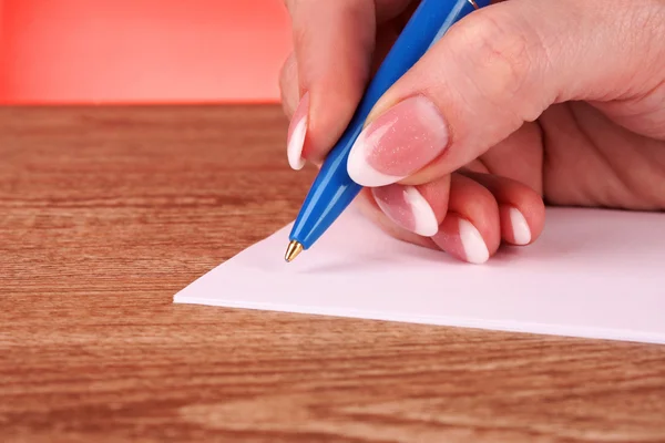 Pen in hand writing on paper — Stock Photo, Image