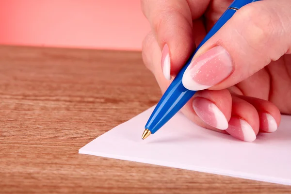 Penna i hand skriva på papper — Stockfoto