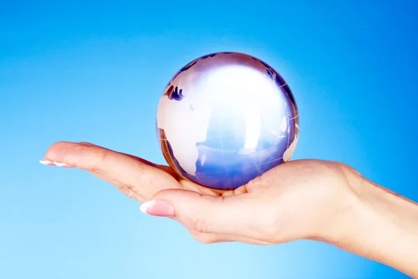 Crystal ball on hand. blue background — Stock Photo, Image