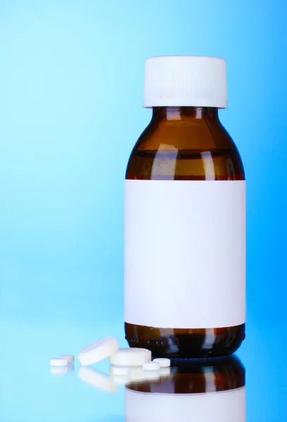 Liquid medicine in glass bottle and pills — Stock Photo, Image