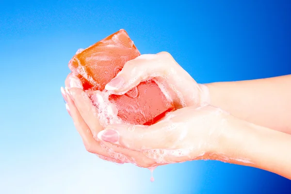 Handen met zeep op blauwe achtergrond — Stockfoto