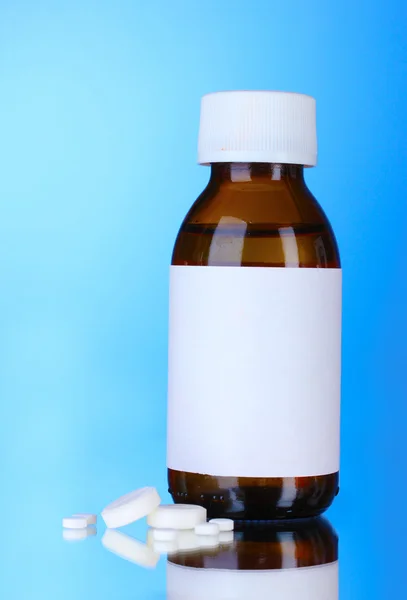Liquid medicine in glass bottle and pills — Stock Photo, Image