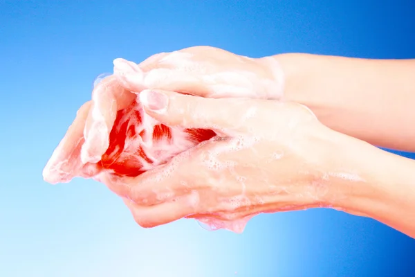 Ręce mydłem na niebieskim tle — Zdjęcie stockowe