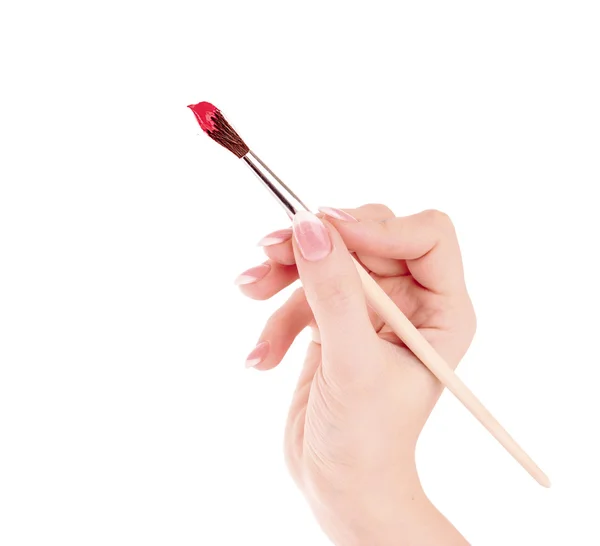 Pincel de pintura com vermelho na mão isolado em branco — Fotografia de Stock
