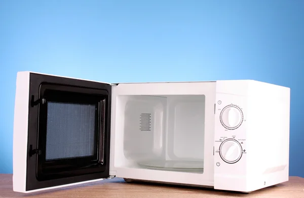 Microwave on blue background — Stock Photo, Image