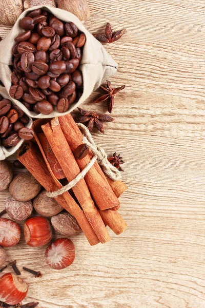 Skořice, káva, muškátový oříšek a lískových ořechů na dřevěné pozadí — Stock fotografie