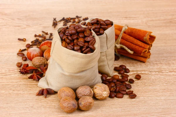 Cinnamon, coffee, nutmeg and hazelnut on wooden background — Stock Photo, Image