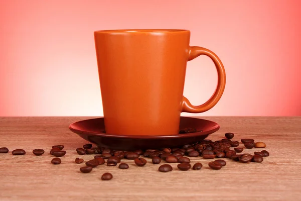 Cup of coffee with coffee grain on red background — Stock Photo, Image