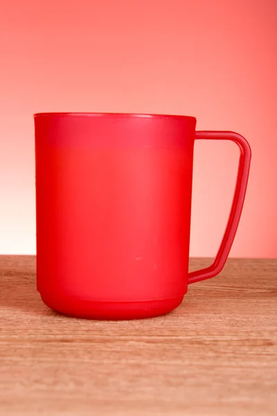 Rote Tasse auf rotem Hintergrund — Stockfoto