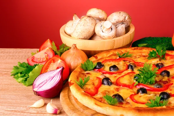Pizza e legumes no fundo vermelho — Fotografia de Stock