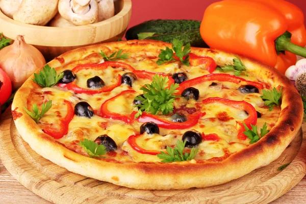 Pizza e legumes no fundo vermelho — Fotografia de Stock