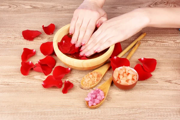 Руки в воде с лепестками роз — стоковое фото