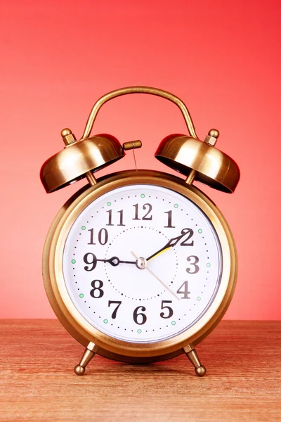Old alarm-clock on red background — Stock Photo, Image