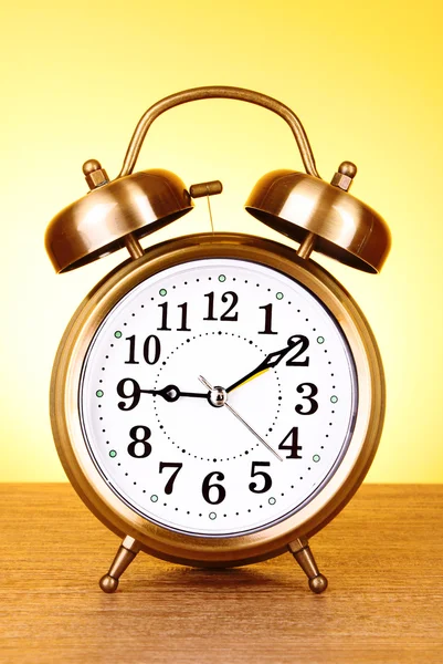 Old alarm-clock on yellow background — Stock Photo, Image