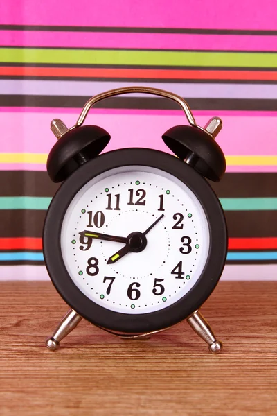 Alarm-clock on color lines background — Stock Photo, Image