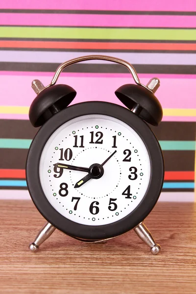 Relógio despertador em linhas de fundo de cor — Fotografia de Stock