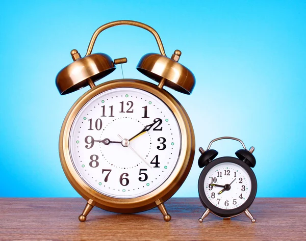 Två klockor med olika tid på blå bakgrund — Stockfoto