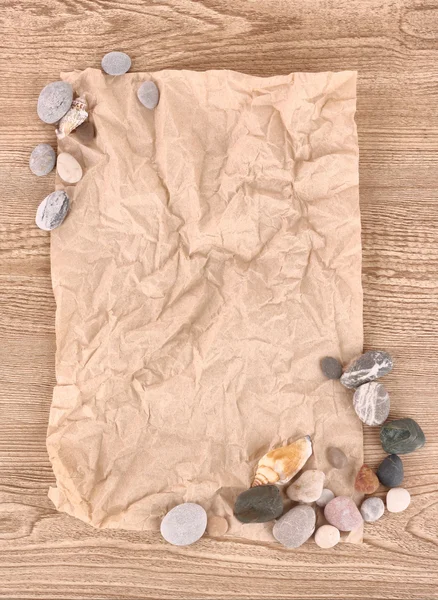 Bruin verfrommeld papier en zee stenen — Stockfoto