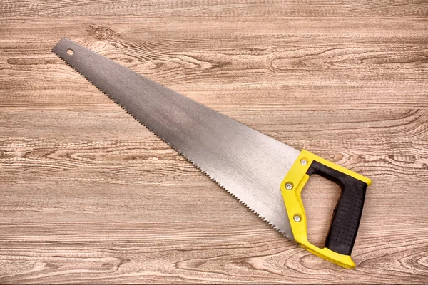 Hand saw on wooden table — Stock Photo, Image