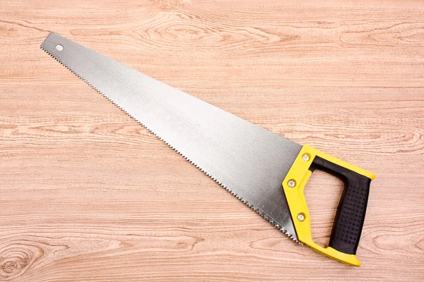 Hand saw on wooden table — Stock Photo, Image
