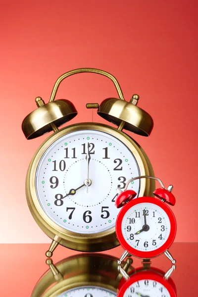 Dos relojes de alarma sobre fondo rojo — Foto de Stock