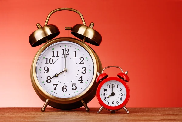 Dos relojes de alarma sobre fondo rojo —  Fotos de Stock