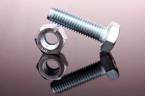 Screw and bolt with reflection on grey background — Stock Photo, Image