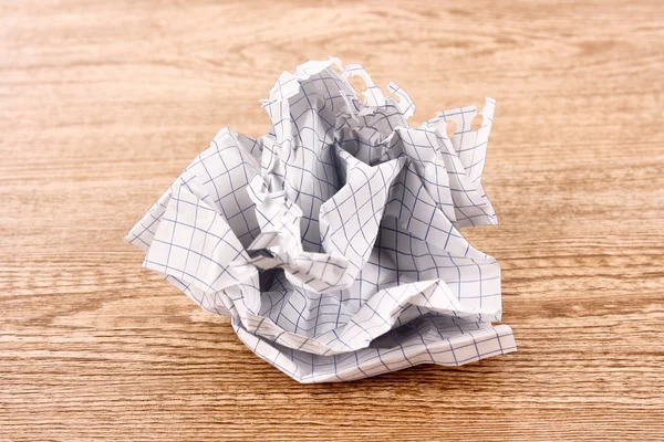 Crumpled paper ball on wooden texture — Stock Photo, Image