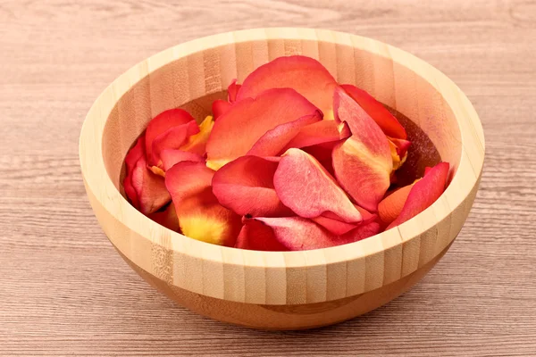 Rose petals in bowl on wooden background — Stock Photo, Image