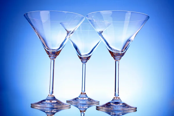 Drei leere Martini-Gläser auf blauem Hintergrund — Stockfoto